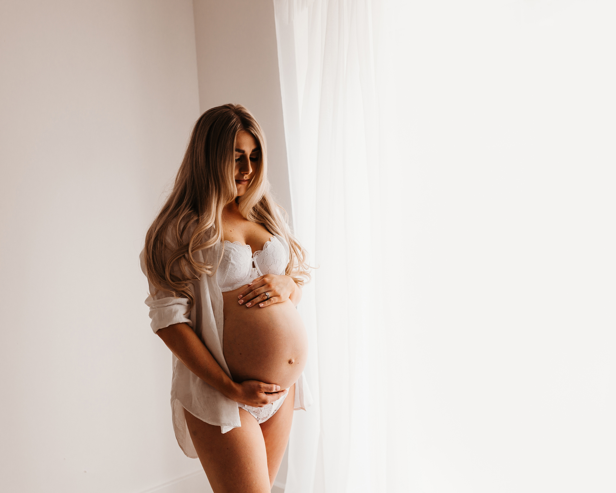 Beautiful blonde pregnant woman in white underwear and shirt by Wirral maternity photographer.