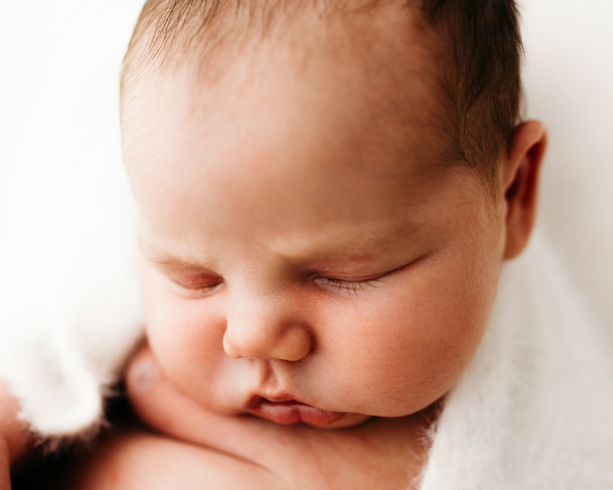 Close up photograph of beautiful baby boy by Wirral newborn photographer.